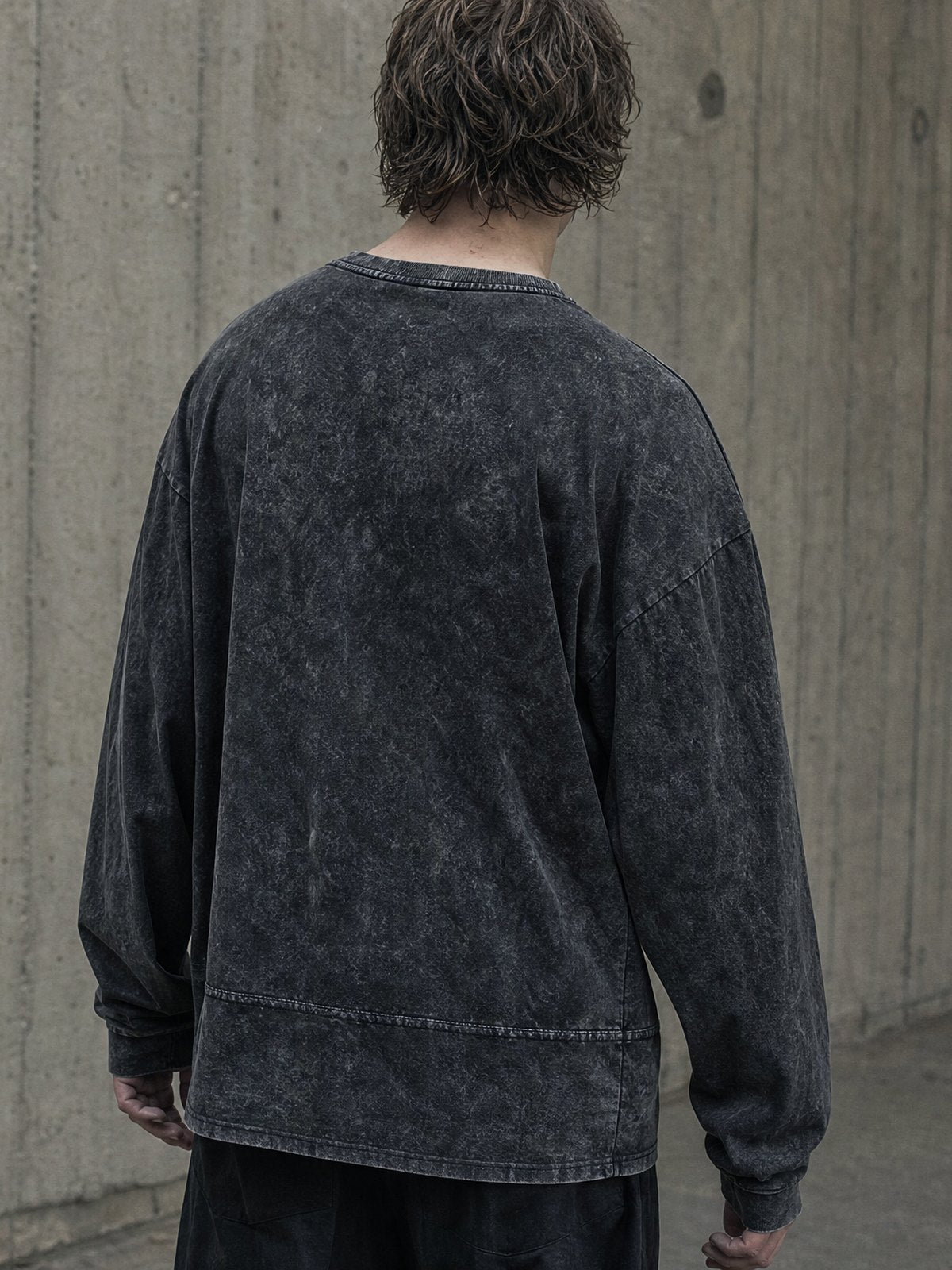 Man in a washed ROCQERX cotton top against a concrete wall